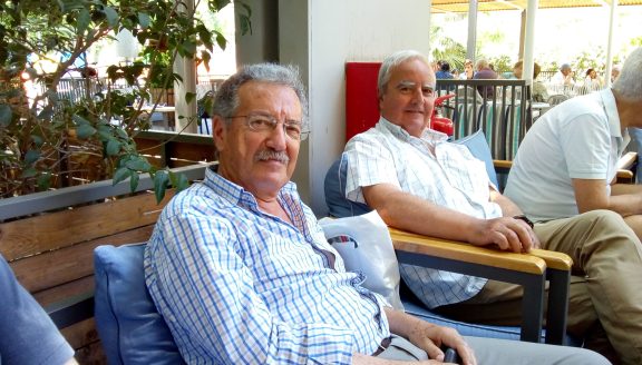 Δύο πρώην αντίπαλοι στην Περιφέρεια Β Αιγαίου Μάκης Αξιώτης (Καλογήρου) και Γιώργος Σίμος (Μουτζούρης), συζητούν, προβληματίζονται αλλά και σχεδιάζουν πίνοντας καφέ στο Πάρκο Μυτιληνης 